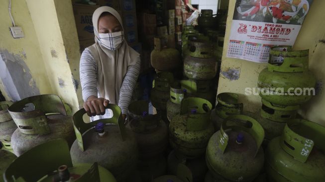 Pedagang menata tabung gas LPG 3 kilogram di agen LPG kawasan Kemang Timur, Jakarta Selatan, Rabu (24/2/2021). [Suara.com/Angga Budhiyanto]