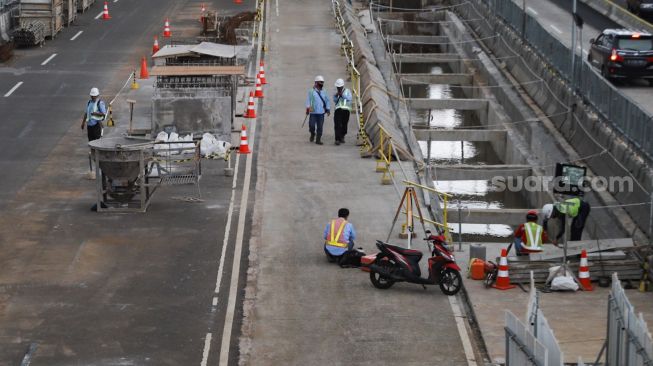 Pekerja beraktivitas di lokasi proyek pembangunan kontruksi MRT Jakarta Fase 2 di MH Thamrin, Jakarta Pusat, Rabu (24/2/2021). [Suara.com/Alfian Winanto]