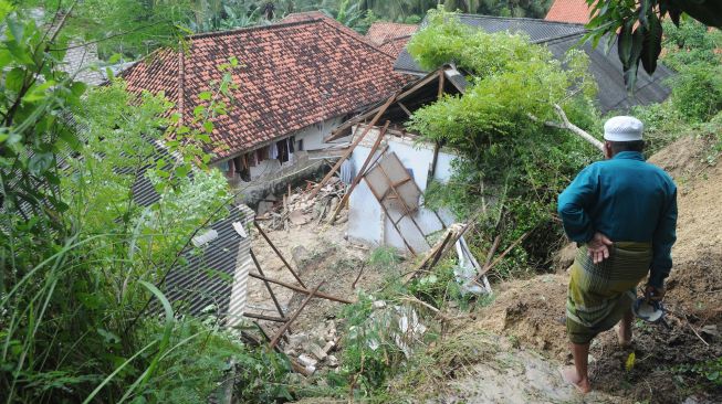 Warga menyaksikan Pesantren An Nidhoniyah yang tertimbun longsor di Desa Bindang, Pamekasan, Jawa Timur, Rabu (24/2/2021).  [ANTARA FOTO/Saiful Bahri]