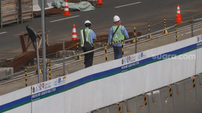 Pekerja beraktivitas di lokasi proyek pembangunan kontruksi MRT Jakarta Fase 2 di MH Thamrin, Jakarta Pusat, Rabu (24/2/2021). [Suara.com/Alfian Winanto]