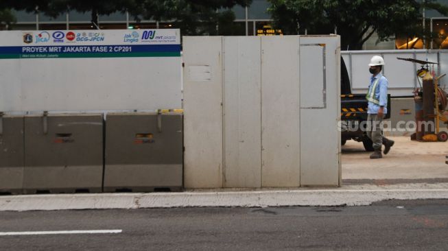 Pekerja beraktivitas di lokasi proyek pembangunan kontruksi MRT Jakarta Fase 2 di MH Thamrin, Jakarta Pusat, Rabu (24/2/2021). [Suara.com/Alfian Winanto]