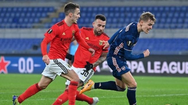 Pemain Arsenal Martin Odegaard berebut bola dengan pemain Benfica dalam pertandingan leg pertama babak 32 besar Liga Europa di Stadio Olimpico, Roma, 19 Februari 2021. [AFP]