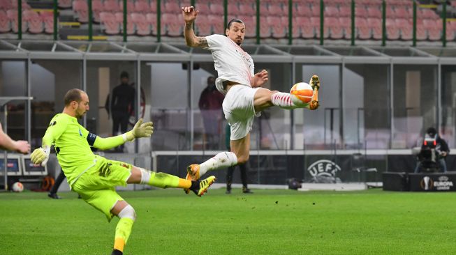 Penyerang AC Milan Zlatan Ibrahimovic berduel dengan  penjaga gawang Red Star, Milan Borjan (kiri) selama pertandingan sepak bola leg kedua AC Milan melawan Red Star  di Stadion San Siro, Milan, Italia, Kamis waktu setempat atau Jumat (26/2/2021) dini hari WIB. Tiziana FABI / AFP