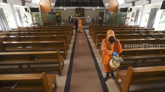 Petugas menyemprotkan cairan disinfektan di Gereja Katolik Santa Catharina Taman Mini Indonesia Indah (TMII), Jakarta Timur, Rabu (18/3/2020). [Suara.com/Angga Budhiyanto]