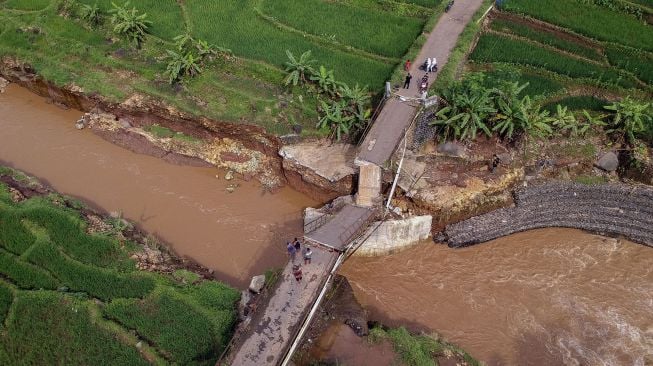 Foto udara kondisi Jembatan Kalipetung yang roboh di Desa Satriyan, Tersono, Kabupaten Batang, Jawa Tengah, Sabtu (27/2/2021). [ANTARA FOTO/Harviyan Perdana Putra]