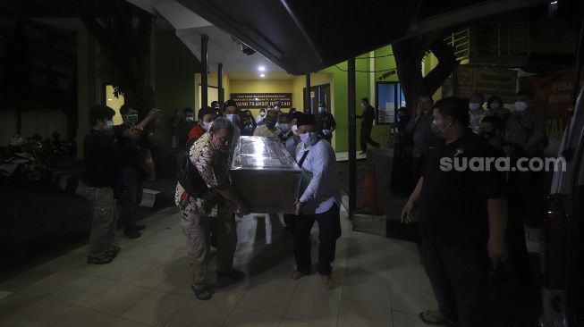 Keluarga dan kerabat membawa peti jenazah anggota Dewan Pengawas KPK Artidjo Alkostar ke dalam mobil ambulans di Rumah Sakit Polri, Kramat Jati, Jakarta, Minggu (28/2/2021). [Suara.com/Angga Budhiyanto]