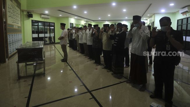 Keluarga dan kerabat menyolatkan jenazah anggota Dewan Pengawas KPK Artidjo Alkostar di Rumah Sakit Polri, Kramat Jati, Jakarta, Minggu (28/2/2021). [Suara.com/Angga Budhiyanto]