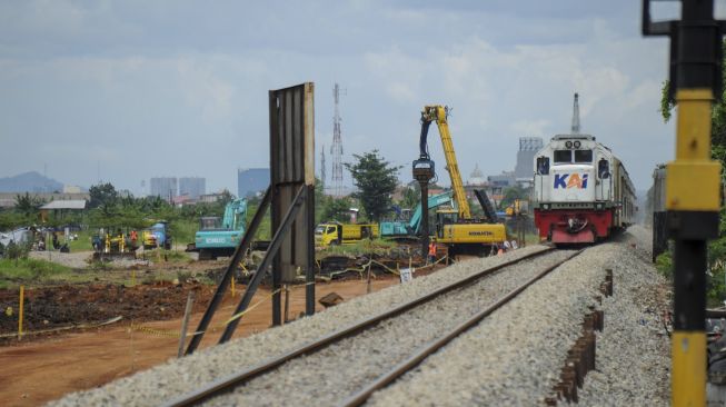 Pekerja menggunakan alat berat untuk menyelesaikan proyek jalur kereta api ganda Kiaracondong-Cicalengka, di Gedebage, Bandung, Jawa Barat, Minggu (28/2/2021). [ANTARA FOTO/Raisan Al Farisi]