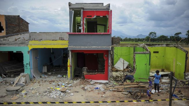 Warga terdampak proyek jalur kereta api ganda Kiaracondong-Cicalengka membawa puing yang masih bisa terpakai dari reruntuhan rumahnya di Panyileukan, Bandung, Jawa Barat, Minggu (28/2/2021). [ANTARA FOTO/Raisan Al Farisi]