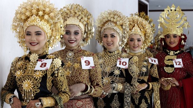 Para model yang memakai kostum adat pengantin daerah yang telah dirias wajahnya antre untuk penilaian pada rangkaian kegiatan wedding expo, di Banda Aceh, Aceh, Minggu (28/2/2021). [ANTARA FOTO / Irwansyah Putra]