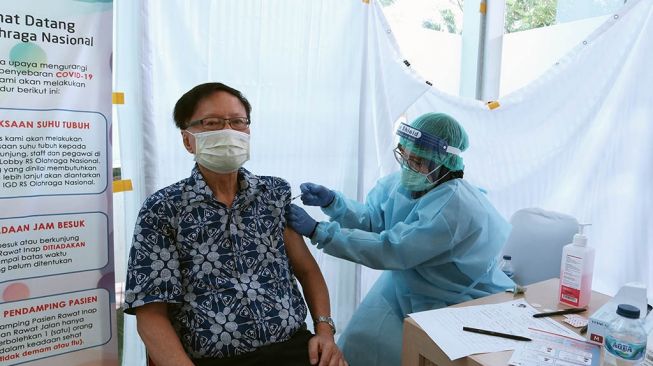 Legenda bulutangkis Indonesia, Tan Joe Hok menerima vaksin Covid-19 di Rumah Sakit Olahraga Nasional, Cibubur, Jakarta Timur, Senin (1/3/2021). [PBSI]