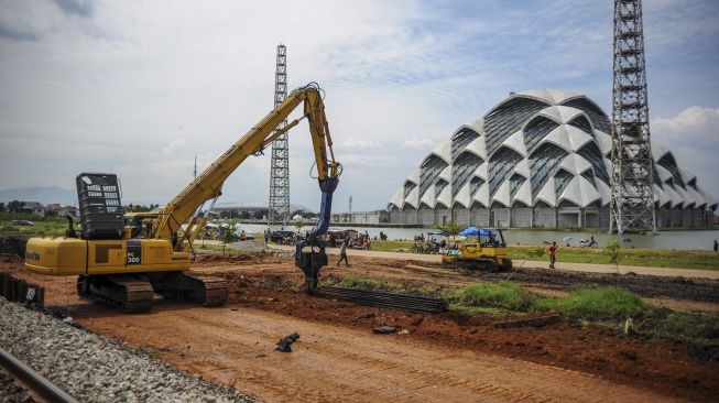 Pekerja menggunakan alat berat untuk menyelesaikan proyek jalur kereta api ganda Kiaracondong-Cicalengka, di Gedebage, Bandung, Jawa Barat, Minggu (28/2/2021). [ANTARA FOTO/Raisan Al Farisi]