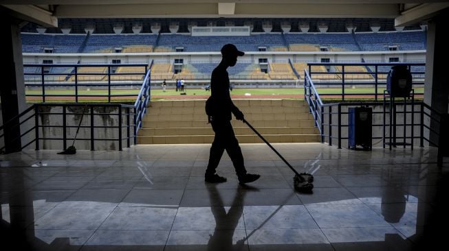 Petugas kebersihan membersihkan tribun Stadion Gelora Bandung Lautan Api (GBLA) di Bandung, Jawa Barat, Senin (1/3/2021). [ANTARA FOTO/Raisan Al Farisi]