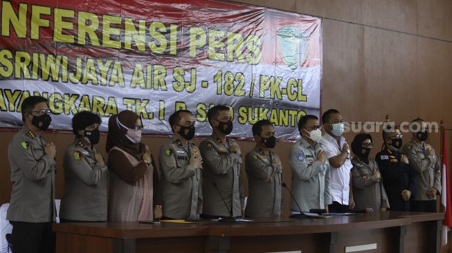 Direktur Pencacatan Sipil Kementerian Dalam Negeri Handayani Ningrum (ketiga kiri), Kepala Rumah Sakit Polri Kramat Jati Brigjen Pol Dr Asep Hendradiana (keempat kiri), Karopenmas Divisi Humas Mabes Polri Brigjen Pol Rusdi Hartono (keempat kiri), Kepala Pusat Kedokteran dan Kesehatan Polri Brigjen Pol Rusdianto (tengah), Direktur Operasional Jasa Raharja Amos Sampetoding (kelima kanan), dan Direktur Utama Sriwijaya Air Jefferson Jauwena (keempat kanan) berfoto bersama usai memberikan keterangan pers terakhir terkait kegiatan operasi DVI Sriwijaya Air SJ-182 di Rumah Sakit Polri, Kramat Jati, Jakarta, Selasa (2/3/2021). [Suara.com/Angga Budhiyanto]