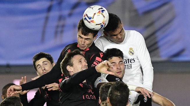 Pemain Real Madrid dan Real Sociedad berusaha menyudul bola dalam laga pekan ke-25 Liga Spanyol di Stadion Alfredo Di Stefano, Selasa (2/3/2021) dini hari WIB. [JAVIER SORIANO / AFP].