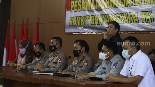 Kepala Pusat Kedokteran dan Kesehatan Polri Brigjen Pol Rusdianto (ketiga kanan) diampingi Direktur Pencacatan Sipil Kementerian Dalam Negeri Handayani Ningrum (kiri) Kepala Rumah Sakit Polri Kramat Jati Brigjen Pol Dr Asep Hendradiana (kedua kiri), Karopenmas Divisi Humas Mabes Polri Brigjen Pol Rusdi Hartono (ketiga kiri), Direktur Operasional Jasa Raharja Amos Sampetoding (kedua kanan), dan Direktur Utama Sriwijaya Air Jefferson Jauwena (kanan) memberikan keterangan pers terakhir terkait kegiatan operasi DVI Sriwijaya Air SJ-182 di Rumah Sakit Polri, Kramat Jati, Jakarta, Selasa (2/3/2021). [Suara.com/Angga Budhiyanto]