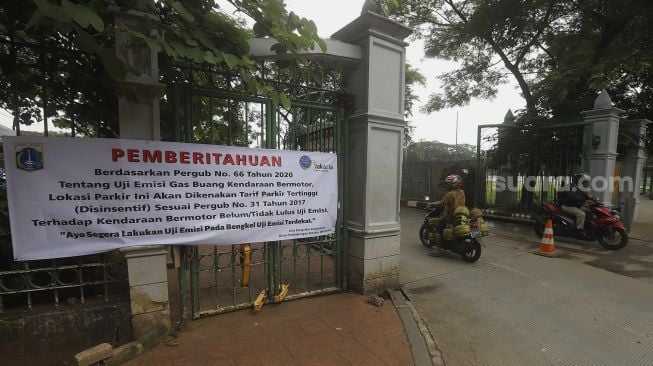 Pengendara sepeda motor memasuki area pelataran parkir IRTI Monas, Jakarta, Selasa (2/3/2021). [Suara.com/Angga Budhiyanto]