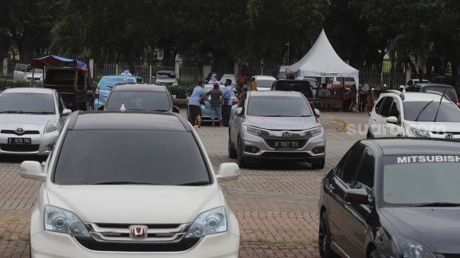 Supir taksi berbincang di pelataran parkir IRTI Monas, Jakarta, Selasa (2/3/2021). [Suara.com/Angga Budhiyanto]