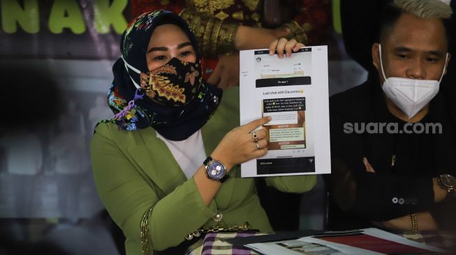 Istri Komedian Daus mini, Shelvie Hana menunjukkan bukti perseteruannya dengan mantan istri Daus, Yunita sari saat konferensi pers di kantor komnas anak, Jakarta Timur, Selasa (2/3/2021). [Suara.com/Alfian Winanto]