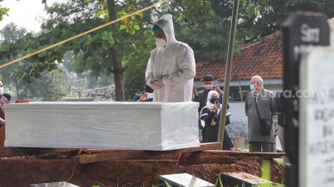 Suami mendiang Presenter Rina Gunawan, Teddy Syah saat melaksanakan prosesi pemakaman sang istri di TPU Tanah Kusir, Jakarta Selatan, Rabu (3/3/2021). [Suara.com/Alfian Winanto]