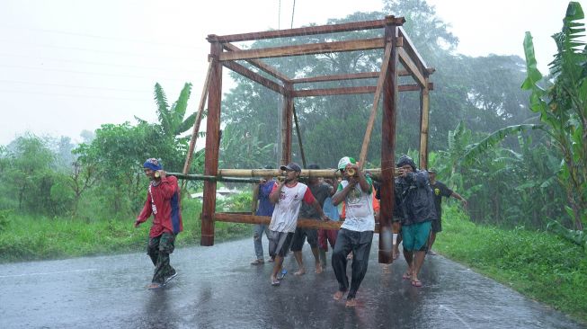 Sejumlah warga mengangkat rangka rumah kayu di Wedomartani, Ngemplak, Sleman, DI Yogyakarta, Rabu (3/3/2021).  ANTARA FOTO/Hendra Nurdiyansyah