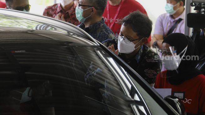 Menteri Kesehatan Republik Indonesia Budi Gunadi Sadikin (kedua kanan) meninjau jalannya vaksinasi COVID-19 dengan sistem 'drive thru' di area parkir Hall C JIExpo Kemayoran, Jakarta, Rabu (3/3/2021). [Suara.com/Angga Budhiyanto]