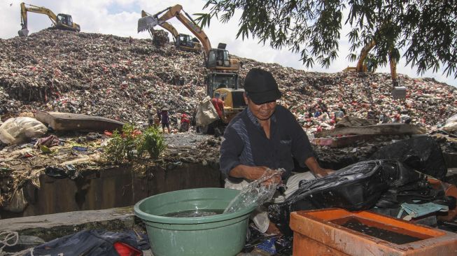 Pemulung mencuci sampah tas di Tempat Pembuangan Akhir (TPA) Cipayung, Depok, Jawa Barat, Kamis (4/3/2021).  ANTARA FOTO/Asprilla Dwi Adha
