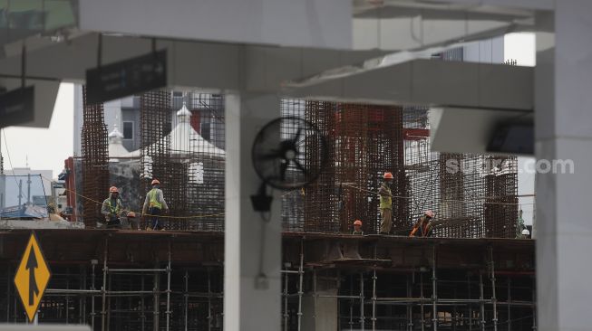 Pekerja menyelesaikan pembangunan Pasar Senen Jaya Blok I dan II, Jakarta, Kamis (4/3/2021). [Suara.com/Angga Budhiyanto]