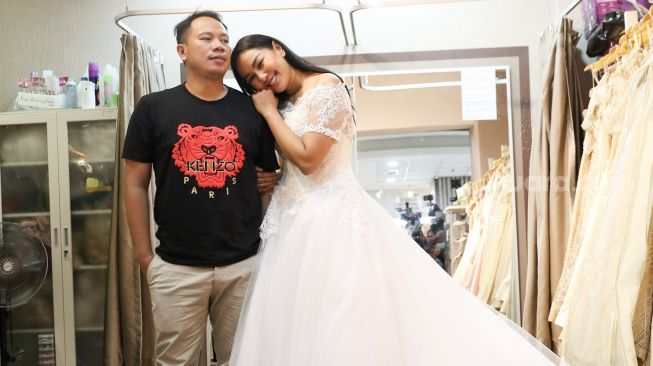 Kalina Oktarani berpose dengan Vicky Prasetyo saat fitting gaun untuk pernikahan mereka di Kawasan Tambora, Jakarta Barat, Jumat (5/3/2021). [Suara.com/Alfian Winanto]