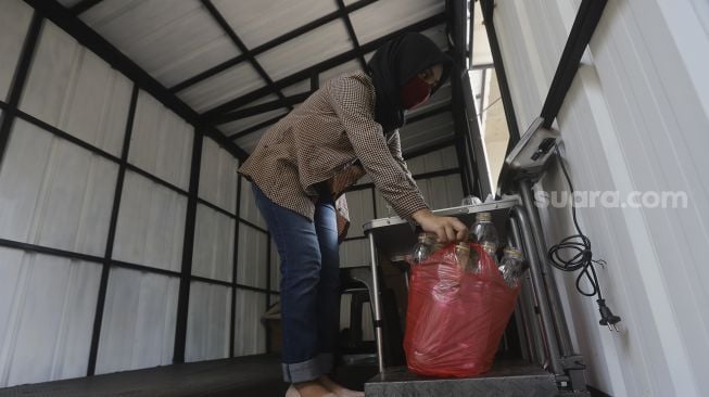 Petugas menimbang sampah anorganik di drop point rekosistem yang berada di Stasiun MRT Blok M, Jakarta, Jumat (5/3/2021). [Suara.com/Angga Budhiyanto]