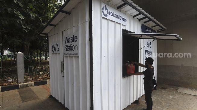 Warga membawa sampah anorganik untuk disetorkan di drop point rekosistem yang berada di Stasiun MRT Blok M, Jakarta, Jumat (5/3/2021). [Suara.com/Angga Budhiyanto]