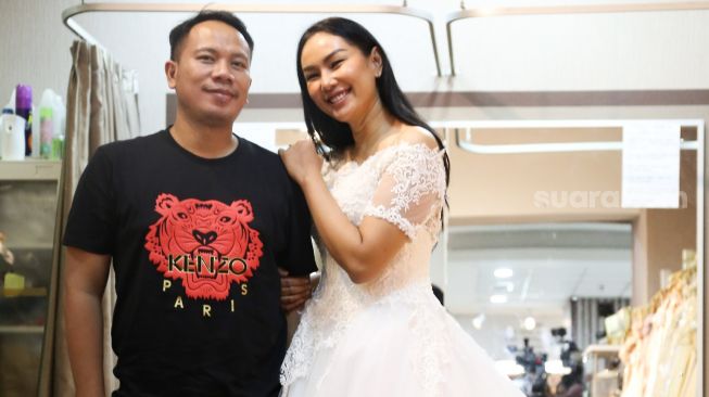 Kalina Oktarani berpose dengan Vicky Prasetyo saat fitting gaun untuk pernikahan mereka di Kawasan Tambora, Jakarta Barat, Jumat (5/3/2021). [Suara.com/Alfian Winanto]