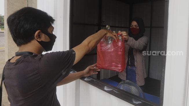 Warga membawa sampah anorganik untuk disetorkan di drop point rekosistem yang berada di Stasiun MRT Blok M, Jakarta, Jumat (5/3/2021). [Suara.com/Angga Budhiyanto]