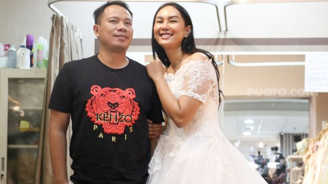 Kalina Oktarani berpose dengan Vicky Prasetyo saat fitting gaun untuk pernikahan mereka di Kawasan Tambora, Jakarta Barat, Jumat (5/3/2021). [Suara.com/Alfian Winanto]