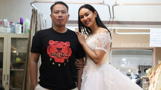 Kalina Oktarani berpose dengan Vicky Prasetyo saat fitting gaun untuk pernikahan mereka di Kawasan Tambora, Jakarta Barat, Jumat (5/3/2021). [Suara.com/Alfian Winanto]