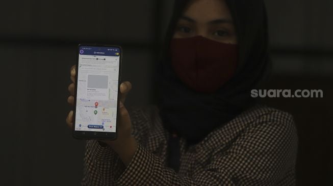 Petugas menunjukkan aplikasi di drop point rekosistem yang berada di Stasiun MRT Blok M, Jakarta, Jumat (5/3/2021). [Suara.com/Angga Budhiyanto]