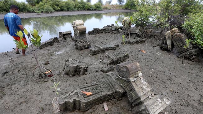 Nelayan melintas di kompleks situs sejarah makam Sundusu Balad yang terbengkalai dan tidak terawat di pesisir Pantai Gampong Pande, Banda Aceh, Aceh, Sabtu (6/3/2021). ANTARA FOTO/Irwansyah Putra