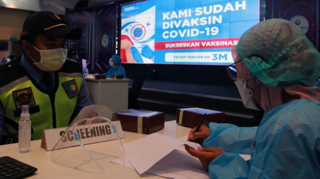 Seorang tenaga medis melakukan pendataan seorang petugas AVSEC saat vaksinasi COVID-19 massal di Bandara Soekarno Hatta, Tangerang, Banten, Sabtu (6/3/2021). ANTARA FOTO/Muhammad Iqbal