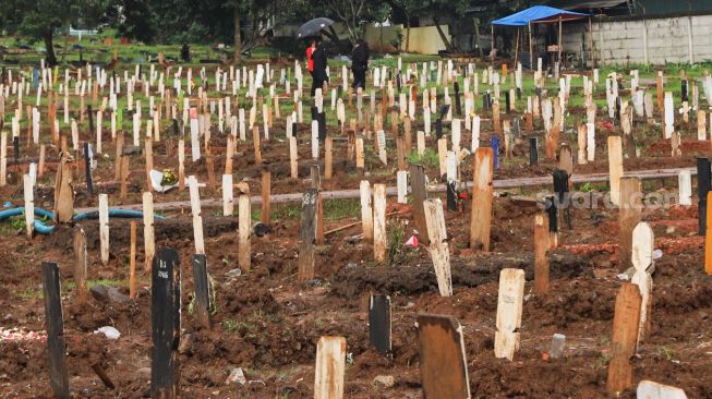 Suasana di area makam khusus Covid-19 di TPU Bambu Apus, Jakarta Timur, Sabtu (6/3/2021). [Suara.com/Alfian Winanto]