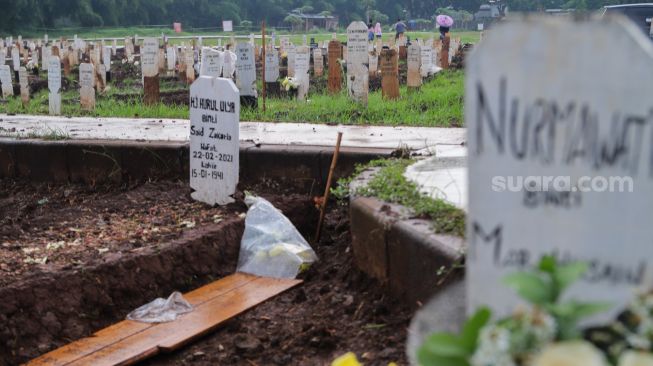 Suasana di area makam khusus Covid-19 di TPU Bambu Apus, Jakarta Timur, Sabtu (6/3/2021). [Suara.com/Alfian Winanto]