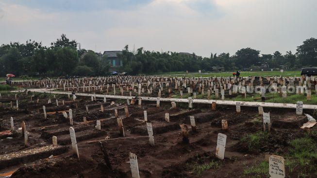 Kondisi makam khusus Covid-19 yang terisi penuh di TPU Bambu Apus, Jakarta Timur, Sabtu (6/3/2021). [Suara.com/Alfian Winanto]