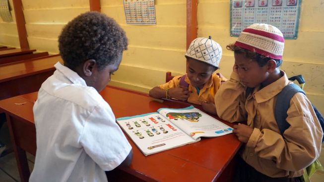 Tiga orang murid tanpa menggunakan masker membaca buku di dalam kelas di SD Al Maarif 1 Kampung Maibo, Kabupaten Sorong, Papua Barat, Sabtu (6/3/2021). ANTARA FOTO/Olha Mulalinda
