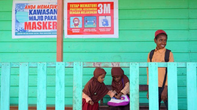 Tiga orang murid tanpa menggunakan masker membaca buku di luar kelas di SD Al Maarif 1 Kampung Maibo, Kabupaten Sorong, Papua Barat, Sabtu (6/3/2021). ANTARA FOTO/Olha Mulalinda
