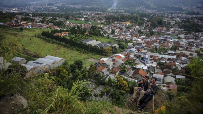 Wisatawan berswafoto di atas puncak Gunung Batu yang merupakan bagian dari Sesar Lembang di Pasirwangi, Lembang, Kabupaten Bandung Barat, Jawa Barat, Minggu (7/3/2021). [ANTARA FOTO/Raisan Al Farisi]