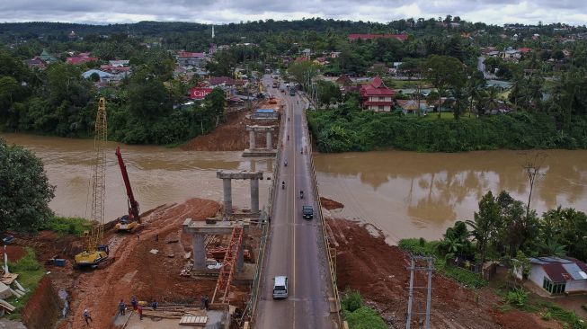 Pekerja menyelesaikan pembangunan Jembatan Merangin 2 di samping Jembatan Merangin, Jalan Lintas Sumatera Jambi-Sumbar, Bangko, Merangin, Jambi, Minggu (7/3/2021). [ANTARA FOTO/Wahdi Septiawan]