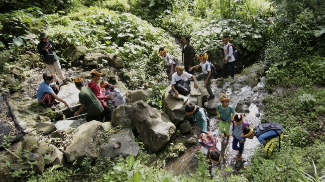 Anak-anak belajar mengenal sumber mata air dalam pembelajaran Jelajah Rimba Sekolah Alam Kampung Baca Taman Rimba (Batara) di Papring, Kalipuro, Banyuwangi, Jawa Timur, Minggu (7/3/2021). [ANTARA FOTO/Budi Candra Setya]