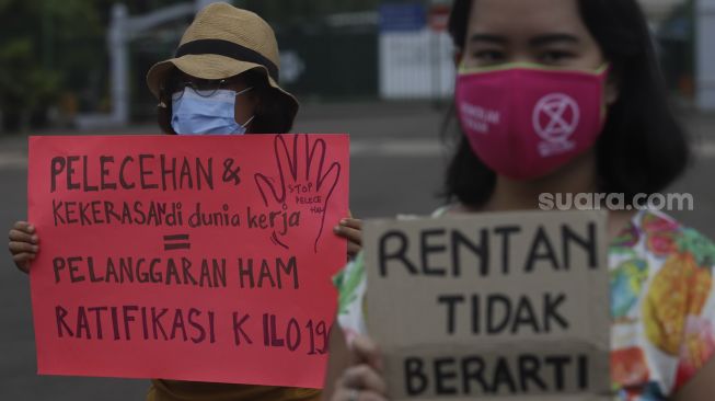 Massa yang tergabung dalam Perempuan Mahardhika membawa poster saat melakukan aksi memperingati Hari Perempuan Internasional di kawasan Patung Kuda Arjuna Wiwaha, Jakarta, Senin (8/3/2021). [Suara.com/Angga Budhiyanto]