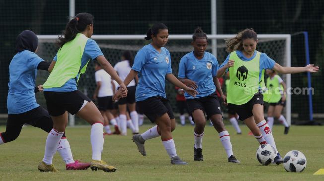 Pemain Timnas sepakbola putri Sabreena Dressler (kanan) berebut bola dengan rekan satu timnya saat mengikuti pemusatan latihan di Lapangan D, Komplek Gelora Bung Karno, Jakarta, Senin (8/3/2021). [Suara.com/Angga Budhiyanto]