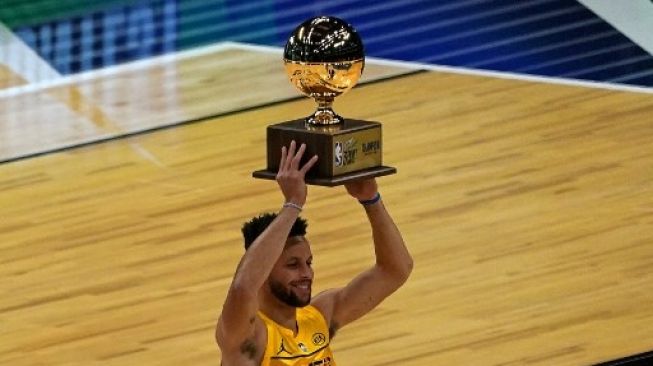 Pebasket Golden State Warriors Stephen Curry (30) mengangkat piala usai memenangi 3 Point Contest NBA All-Star di State Farm Arena, Atlanta, Georgia, AS (7/3/2021). TIMOTHY A. CLARY / AFP