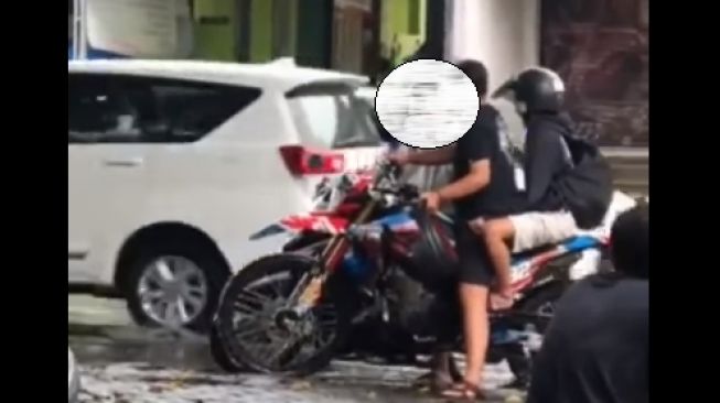 Pemotor memukul kepala wanita karena diduga tak terima kecipratan air (Facebook)